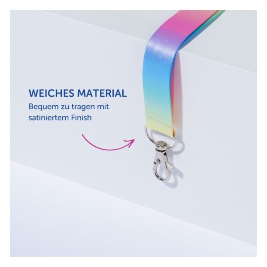 Das Bild zeigt ein buntes Band, das sein weiches Material und die satinierte Oberfläche hervorhebt, mit einem angebrachten Metallclip. Der Text auf Deutsch erwähnt seinen Komfort und seine Qualität.