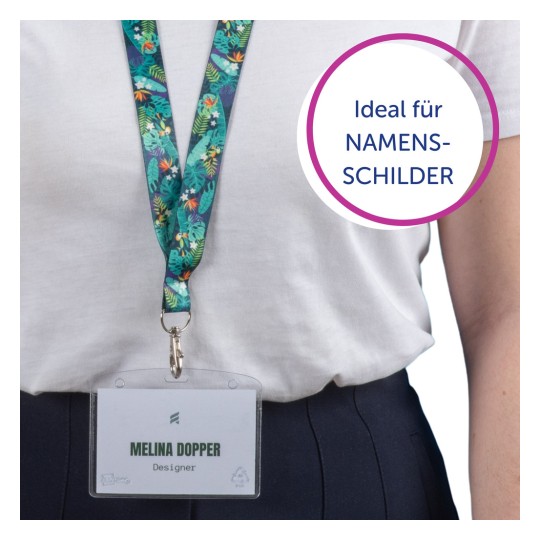 Das Bild zeigt eine Person, die ein weißes Hemd und ein buntes Schlüsselband mit einem daran befestigten Namensschild trägt. Auf dem Namensschild steht 'Melina Dopper', mit der Bezeichnung 'Designer'. Es gibt eine kreisförmige Grafik mit der Aufschrift 'Ideal für NAMENSSCHILDER'.