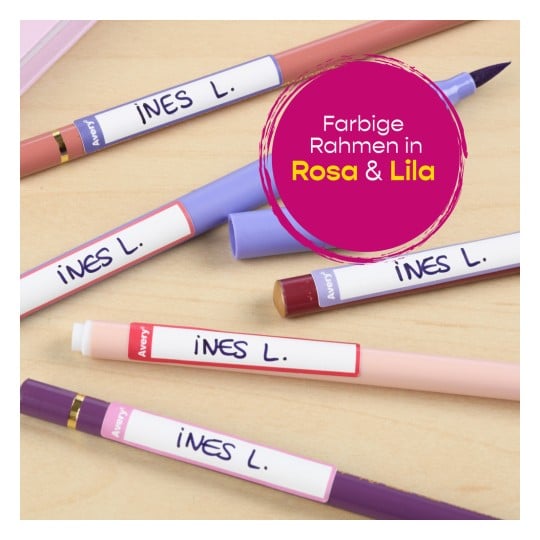 Das Bild zeigt mehrere bunte Stifte und Marker in Rosa- und Lilatönen, die jeweils mit 'INES L.' auf einer Holzoberfläche beschriftet sind.
