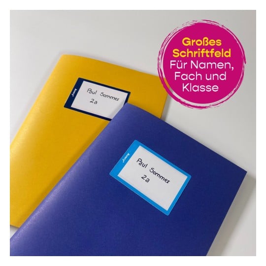 Das Bild zeigt zwei Ordner, einen gelben und einen blauen, beide mit dem Namen 'Paul Sommer' und der Klasse '2a' beschriftet. Außerdem gibt es eine runde Grafik in Rosa, die ein großes Beschriftungsfeld für Namen, Fächer und Klassen anzeigt.