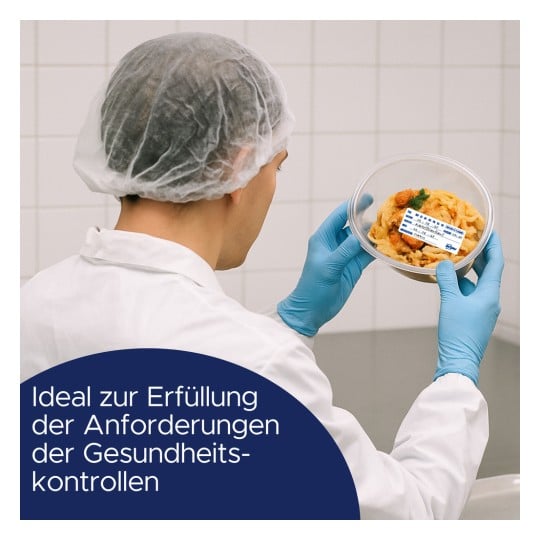 Eine Person in Schutzkleidung hält einen Behälter mit Lebensmitteln, der ein Etikett trägt. Die Umgebung scheint eine saubere, gereinigte Küchenumgebung zu sein, die die Einhaltung von Gesundheitsvorschriften betont.
