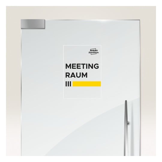 Das Bild zeigt eine Tür mit einem Schild, auf dem 'MEETING RAUM III' neben einem gelben Balken und dem Logo von 'Avery Zweckform' steht.