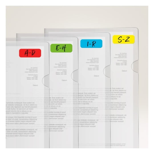 Das Bild zeigt eine Reihe von transparenten Plastikmappen, die nebeneinander angeordnet sind, jede mit einer Beschriftung, die auf Abschnitte hinweist, die nach Buchstabenbereichen organisiert sind: A-D in Rot, E-H in Grün, I-R in Blau und S-Z in Gelb. Sie enthalten gedruckte Dokumente, obwohl der Text teilweise verdeckt ist.