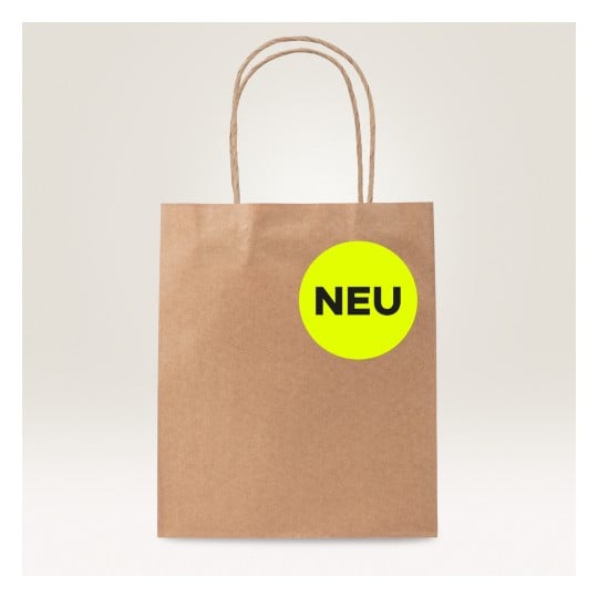 Das Bild zeigt eine braune Papiereinkaufstüte mit einem kreisförmigen neon-gelben Etikett, auf dem in schwarzer Schrift das Wort 'NEU' steht.
