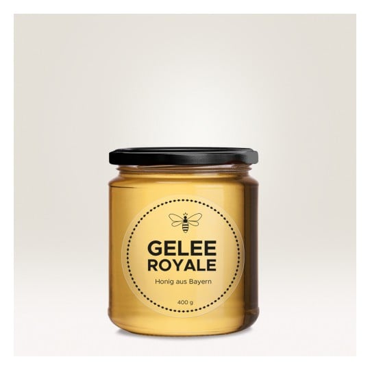 Das Bild zeigt ein Glas Gelee Royale, ein Bienenprodukt, mit einem Etikett, das angibt, dass es sich um Honig aus Bayern handelt. Das Glas ist klar mit einem schwarzen Deckel und enthält 400 Gramm.