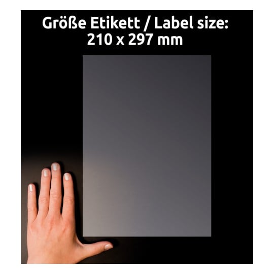 Das Bild zeigt eine Hand neben einem grauen rechteckigen Blatt Papier, dessen Abmessungen sowohl auf Deutsch als auch auf Englisch mit 210 x 297 mm angegeben sind. Der Hintergrund ist schwarz.