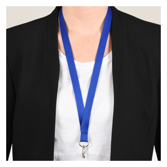 Das Bild zeigt eine Person, die einen schwarzen Blazer über einem weißen Hemd trägt, mit einem blauen Lanyard um den Hals.