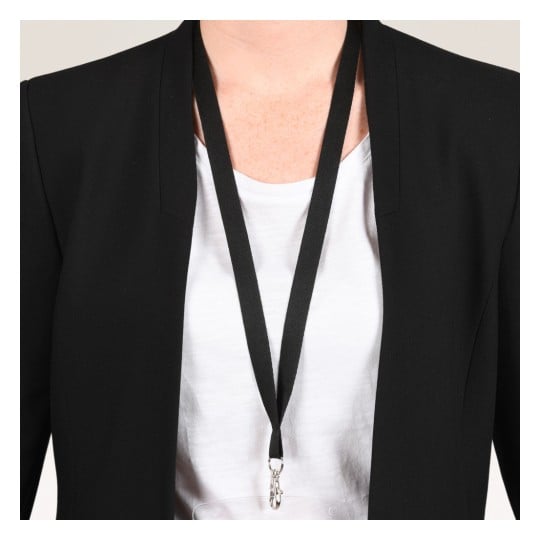 Das Bild zeigt eine Person, die einen schwarzen Blazer über einem weißen Hemd trägt, mit einem Schlüsselband um den Hals.