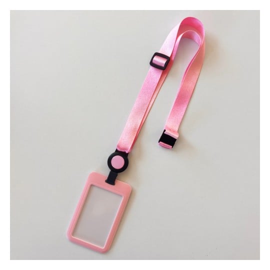 Das Bild zeigt ein rosa Schlüsselband mit einem transparenten ID-Halter. Es hat ein Satin-Finish und einen schwarzen Clip zur Einstellung.