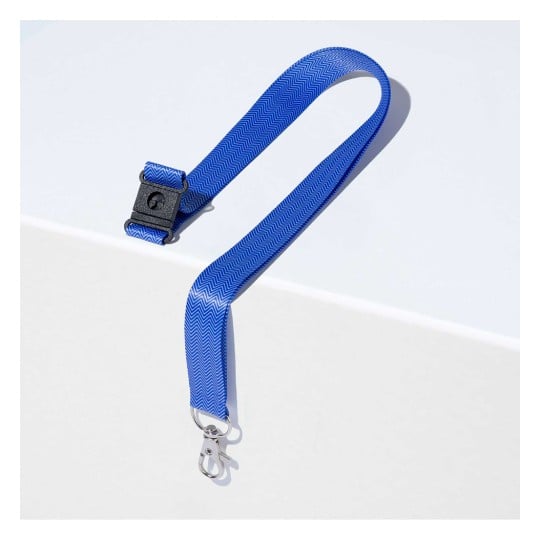 Das Bild zeigt ein blaues Band mit einem Zickzackmuster und einem Metallverschluss. Es liegt auf einer weißen Oberfläche, die sein Design und seine Farbe hervorhebt.