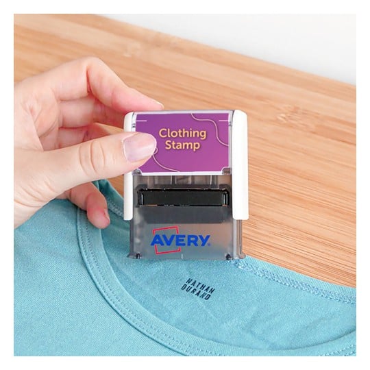 Das Bild zeigt eine Person, die einen Kleiderstempel über einem Hemd hält. Der Stempel ist mit 'Kleiderstempel' und dem Markennamen 'Avery' gekennzeichnet.