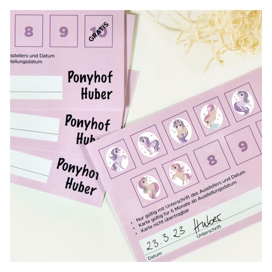 Das Bild zeigt eine Reihe von rosa Tickets oder Karten für 'Ponyhof Huber' mit Einhornillustrationen und einem Feld für Unterschriften. Auf einer der Karten steht ein Datum.