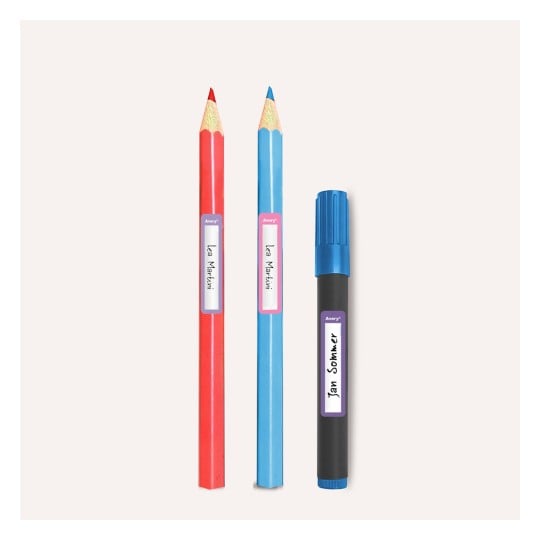 Das Bild zeigt zwei Buntstifte, einen roten und einen blauen, neben einem schwarzen Marker, die jeweils mit Etiketten versehen sind.