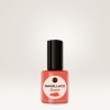 Ein rundes Folienetikett klebt auf einer Nagellack-Flasche.