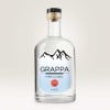 Eine Schnapsflasche mit einem Etikett in Freiform und Aufschrift Grappa ist zu sehen.