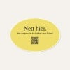 Ein ovaler, gelber "Nett hier Sticker". Es steht der Text "Nett hier. aber designen Sie doch selbst coole Sticker" inkl. einem QR Code auf dem Aufkleber.