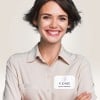 Auf der Bluse einer Frau klebt ein bedrucktes Namensschild.
