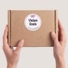Hand hält Paket mit Danke-Sticker in rosa.
