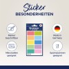 Das Bild zeigt ein Set von Design-Aufklebern in verschiedenen Farben, die als beschreibbar mit Markern, mikrowellengeeignet und spülmaschinenfest gekennzeichnet sind. Es wird hervorgehoben, dass das Produkt in Deutschland hergestellt wird.