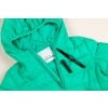 Eine grüne Steppjacke mit Kapuze, die ein Etikett und einen schwarzen Marker daneben aufweist.