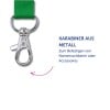 Das Bild zeigt einen metallischen Karabiner, der an einem grünen Riemen befestigt ist, mit Text auf Deutsch, der seine Verwendung zum Anbringen von Namensschildern oder Zubehör erklärt.