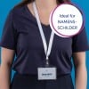 Das Bild zeigt eine Person, die ein marineblaues Hemd trägt, mit einem Namensschild, das an einem Umhängeband um den Hals hängt. Auf dem Namensschild steht 'MELINA DOPPER, Designerin' und es gibt eine kreisförmige Grafik, die auf Deutsch 'Ideal für NAMENS-SCHILDER' sagt.