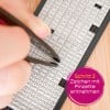 Das Bild zeigt eine Person, die mit einer Pinzette Buchstaben aus einem mit verschiedenen Buchstabenkacheln gefüllten Tablett aufnimmt. Der eingeblendete Text gibt an, dass es sich um Schritt zwei eines Prozesses handelt, bei dem Zeichen entfernt werden.