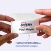 Das Bild zeigt eine Person, die einen Kartenhalter mit einem Namensschild darin hält, auf dem 'Avery Paul Meyer' steht. Der Hintergrund ist hellviolett, und es gibt eine Nachricht, die das robuste Material für einfaches Einfügen hervorhebt.