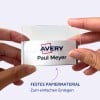 Das Bild zeigt eine Person, die ein durchsichtiges Namensschild mit dem Namen 'Paul Meyer' und dem Logo von 'Avery' hält. Das Schild scheint aus robustem Papiermaterial zu bestehen, das sich leicht einfügen lässt.