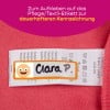 Das Bild zeigt einen rosafarbenen Stoffhintergrund mit einem Kleidungsetikett, das die Pflegehinweise deutlich zeigt. Auf dem Etikett steht der Name 'Clara P.'.
