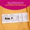 Das Bild zeigt ein Kleidungsetikett mit dem Namen 'Alba F.', begleitet von Pflege- und Textilinformationen auf Deutsch. Der Hintergrund ist gelb und das Etikett befindet sich auf einem weichen Stoff.