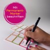 Das Bild zeigt eine Hand, die mit einem Permanentmarker auf ein Etikett schreibt. Das Etikett hat bunte Rahmen, und ein Text ist sichtbar, möglicherweise ein Name. Der Hintergrund ist schlicht und weiß.