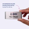 Das Bild zeigt eine Hand, die ein Namensschild hält, auf dem 'AVERY Paul Meyer' mit einer Edelstahloptik steht. Das Schild hat die Maße 70 x 30 mm und repräsentiert ein Set von 20 Namensschildern.