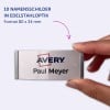Das Bild zeigt eine Person, die ein Namensschild mit der Aufschrift 'Avery Paul Meyer' hält. Das Abzeichen ist silberfarben mit einer Plastikabdeckung und misst 80 x 34 mm.