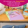 Ein bunter Arbeitsplatz mit Farbstiften, Papier, einem Behälter und Snacks, der eine kreative und lehrreiche Umgebung für Kinder nahelegt.