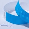 Das Bild zeigt ein blaues Armband mit Wassertropfen darauf, zusammen mit einem Etikett, das 'WASSERFEST' anzeigt, was darauf hindeutet, dass es wasserdicht ist.