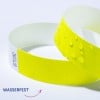 Das Bild zeigt zwei gelbe wasserabweisende Armbänder, eines mit Wassertropfen darauf, neben einem Etikett mit dem Wort 'Wasserfest', das darauf hinweist, dass es wasserdicht ist.