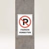 Das Bild zeigt ein Schild mit einem großen roten Kreis und einer diagonalen Linie, die den Buchstaben 'P' durchstreicht, was darauf hinweist, dass Parken verboten ist. Das Schild hat den Text 'PARKEN VERBOTEN' in Deutsch. Es ist auf einem Betonsäule montiert.