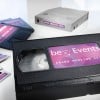 The image features a VHS tape labeled 'beEvents Sales Meeting 2014,' alongside several other media formats, including what appears to be a disk and another VHS tape, all arranged on a white background.