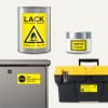 Das Bild zeigt eine silberne Dose mit entzündlicher Farbe und einem Warnhinweis, ein kleines Glas mit einem 'Gratisprobe'-Etikett, eine metallene Box mit einem 'Keine Werbung'-Schild und einen schwarzen Werkzeugkasten mit einem gelben Deckel und einem Inventaretikett.