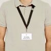 Das Bild zeigt eine Person, die ein Polohemd und ein Lanyard mit einem Namensschild trägt, auf dem 'B. Carlos' und 'MARKETING DIRECTOR' steht. Das Namensschild ist an dem Lanyard befestigt, das schwarz ist.
