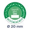Das Bild zeigt eine kreisförmige Grafik, die eine Zertifizierung anzeigt, beschriftet mit 'Geprüft gem. VDE', mit Zahlen um den Umfang und einem Durchmesser von 20 mm.