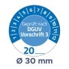 Das Bild zeigt ein Messgerät mit Zahlen von 1 bis 12. Es beinhaltet den Text 'Geprüft nach DGUV Vorschrift 3' und zeigt eine Messung von 30 mm an.