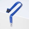 Das Bild zeigt ein blaues Band mit einem Zickzackmuster und einem Metallverschluss. Es liegt auf einer weißen Oberfläche, die sein Design und seine Farbe hervorhebt.