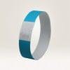 Das Bild zeigt ein blaues Armband aus Papiermaterial. Es hat eine glatte Oberfläche mit einem Design und einer darauf gedruckten Nummer.