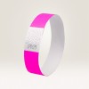 Das Bild zeigt ein rosa Armband mit einem weißen Abschnitt, der ein wellenförmiges Linienmuster und den Zahlencode '070129' aufweist.