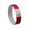 Das Bild zeigt ein rotes Armband aus Papier oder Plastik, mit einem weißen Abschnitt, der ein Zickzack-Muster und eine darauf gedruckte Nummer enthält, wahrscheinlich zu Identifikationszwecken verwendet.