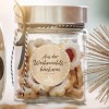 Das Bild zeigt ein Glasgefäß, gefüllt mit festlichen Keksen, beschriftet auf Deutsch mit 'Aus der Weihnachtsbäckerei', was darauf hinweist, dass sie aus der Weihnachtsbäckerei stammen. Das Gefäß ist elegant mit einem Band verziert, und in der Nähe befinden sich dekorative Elemente, einschließlich eines sternförmigen Ornaments.