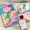 Das Bild zeigt ein farbenfrohes Stickerbuch mit dem Titel 'Mein Stickerbuch Meerjungfrau', das eine Meerjungfrau und verschiedene Meerestiere darstellt, zusammen mit Stickerbögen und einem Malbuch. Das Design ist lebendig und richtet sich an Kinder.